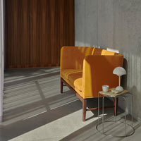 Modern two-seat sofa in vibrant mustard yellow with a smooth fabric finish, set against a neutral background.