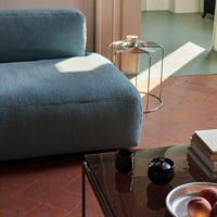 Soft blue couch with a textured fabric, set against warm terracotta flooring and modern metal accents.