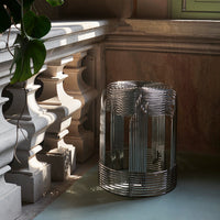 Silver wire basket with a sleek, modern design, featuring a shiny finish and geometric patterns, set against a soft backdrop.