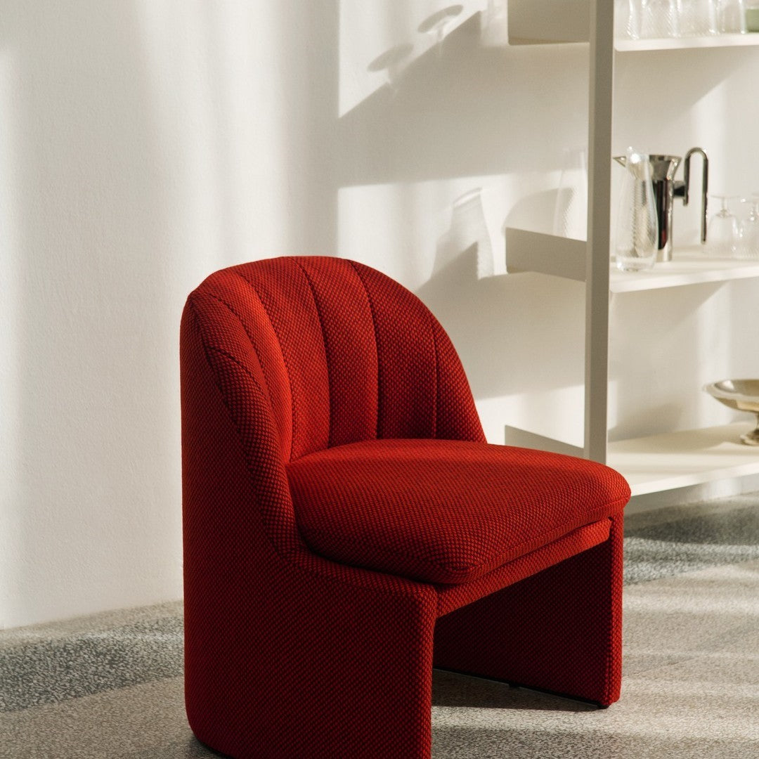 Red patterned chair with curved backrest, enhancing modern decor appeal. Soft texture with a vibrant color.