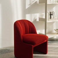 Red patterned chair with curved backrest, enhancing modern decor appeal. Soft texture with a vibrant color.