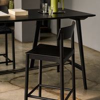 Black wooden chair and table with subtle earthy tones and textures, complementing a modern decor.