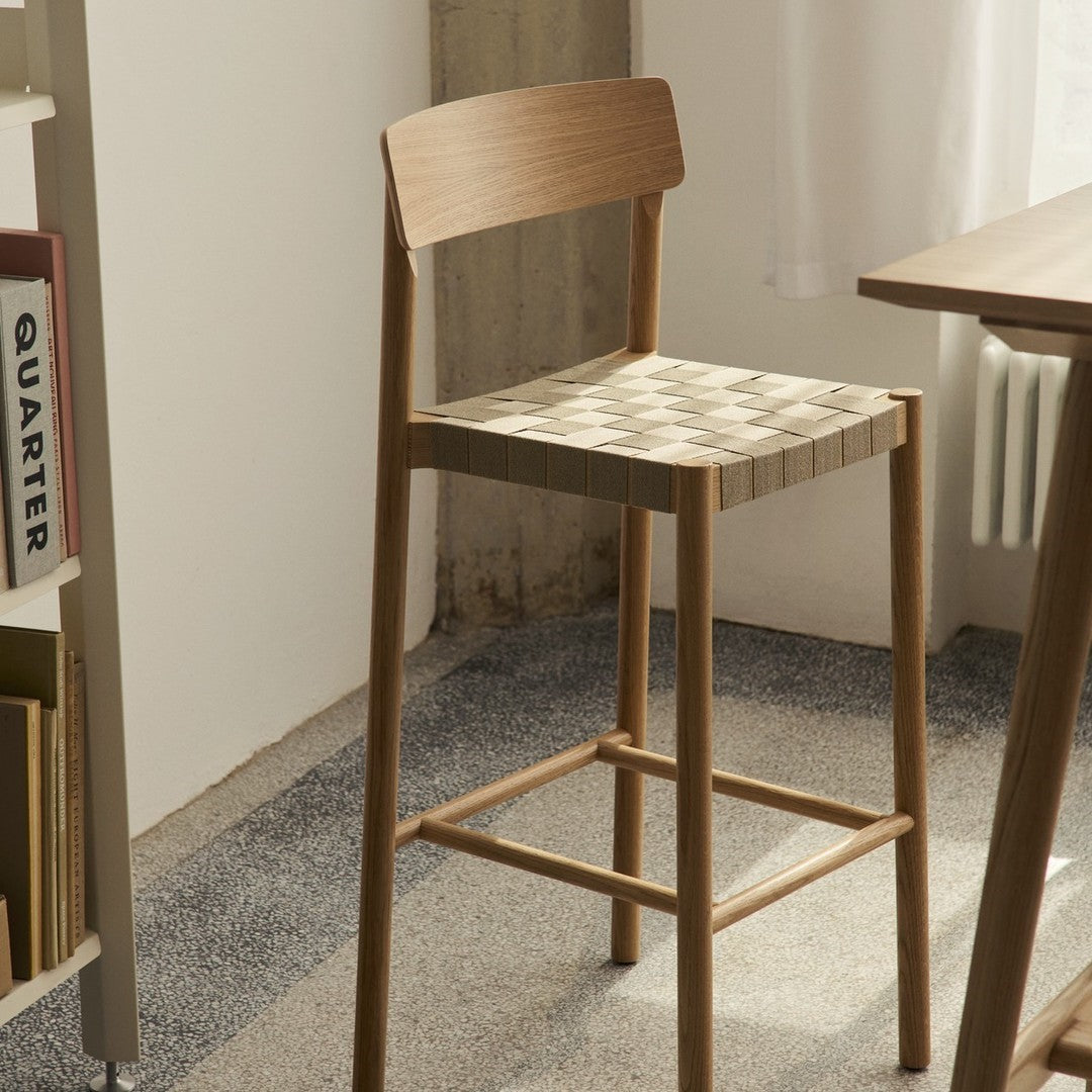 Light wood bar stool with a woven, checkered pattern in neutral tones, adding a modern touch to any space.