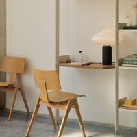 Light wood chairs and shelves with a soft beige backdrop, showcasing minimalist design and muted color palette.
