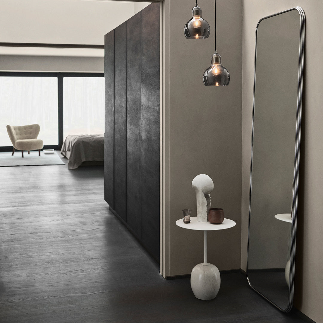 Modern room with dark gray walls, sleek black mirrors, and neutral-toned decor accents, featuring soft lighting.