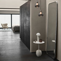 Modern room with dark gray walls, sleek black mirrors, and neutral-toned decor accents, featuring soft lighting.