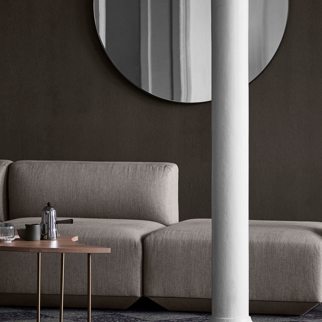 "Modern gray sofa with clean lines, featuring a soft fabric texture, set against a dark, minimalist background."