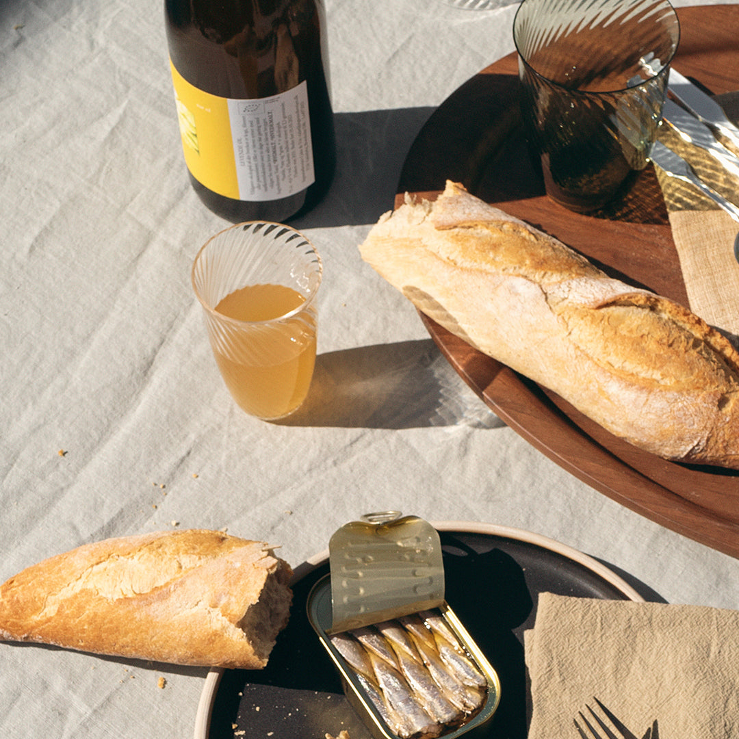 Artisan bread on a rustic table with wood and glass textures, featuring warm beige and earthy tones.