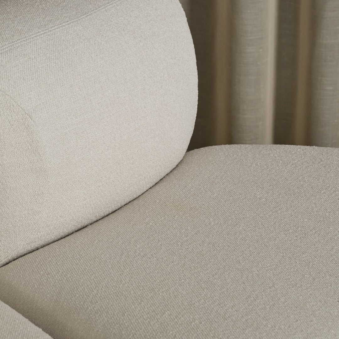 Light beige upholstered chair with a subtle textured pattern, featuring a soft, neutral color palette.