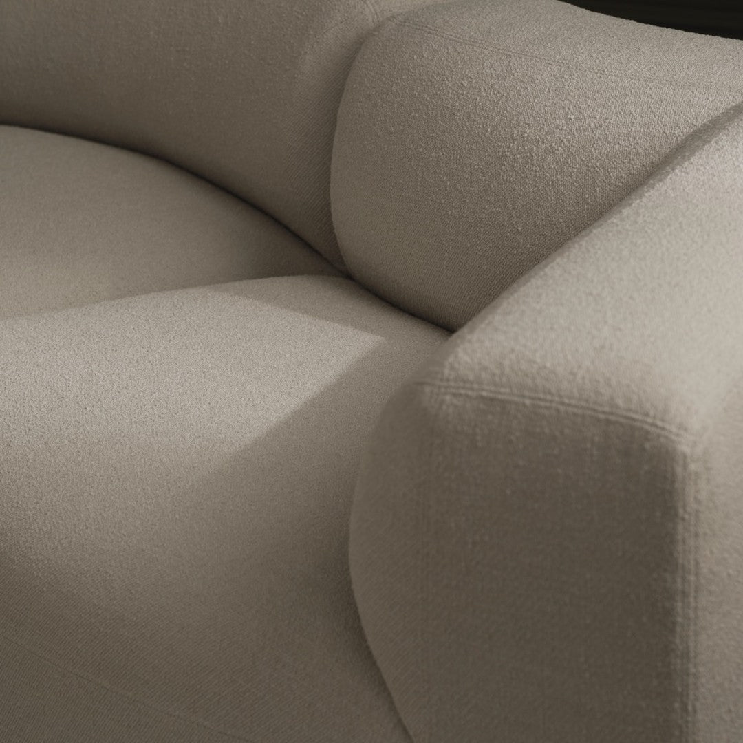 Beige textured fabric upholstery with soft, rounded cushions and subtle patterns. Ideal for modern interior design.