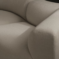 Beige textured fabric upholstery with soft, rounded cushions and subtle patterns. Ideal for modern interior design.