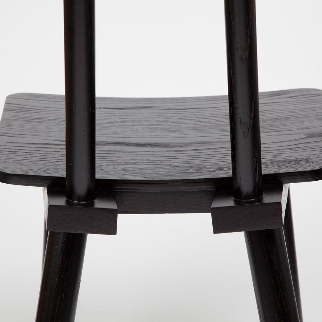 Black wooden chair with smooth, matte finish and sleek, minimalist design. Elegant and modern aesthetic.