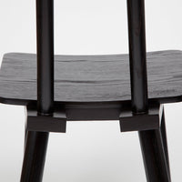 Black wooden chair with smooth, matte finish and sleek, minimalist design. Elegant and modern aesthetic.