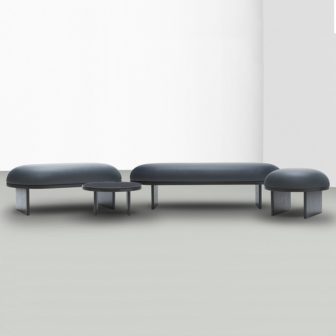 Modern three-piece sofa set in dark gray with smooth, rounded forms and minimalist design.