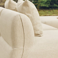 Beige fabric sofa with textured upholstery and plush, rounded back cushions for a cozy, modern look.