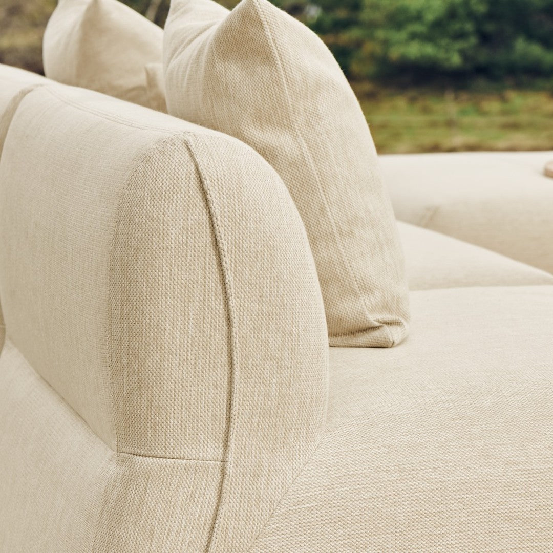 Beige textured fabric sofa with soft, rounded edges and matching plush cushions. Elegant and modern design.