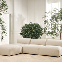 Beige sectional sofa with smooth upholstery, minimalistic design, and no visible patterns, set in a bright, airy room.