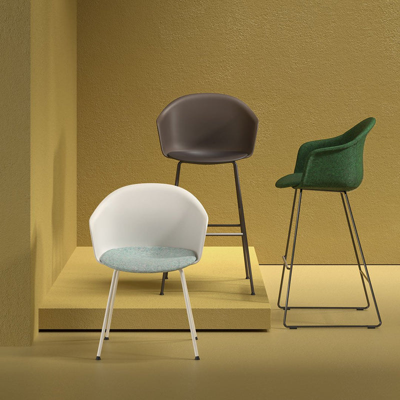 Three modern chairs in white, chocolate brown, and green fabrics against a golden backdrop, showcasing unique textures.