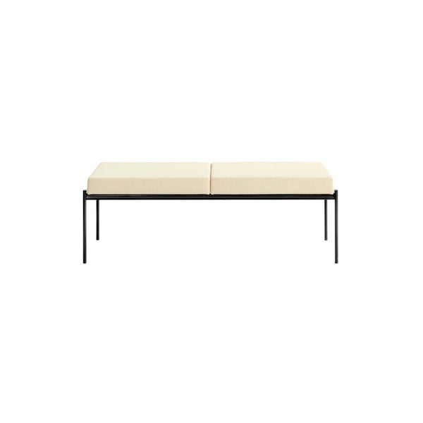 Cream-colored cushioned bench with a sleek black metal frame, featuring a minimalist design. Perfect for modern decor.
