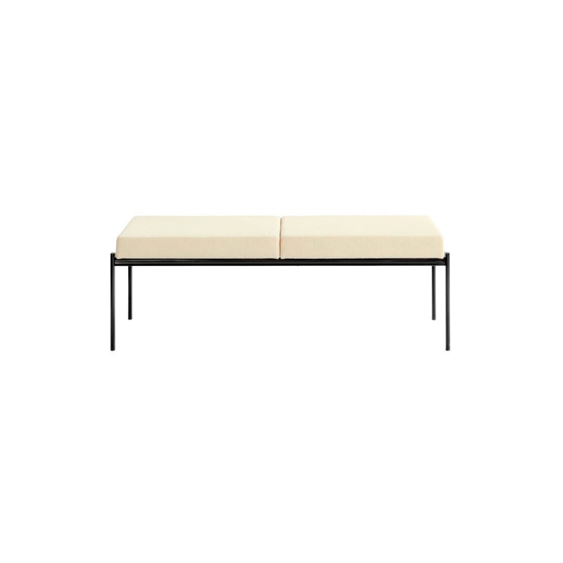 Cream-colored cushioned bench with a sleek black metal frame, featuring a minimalist design. Perfect for modern decor.