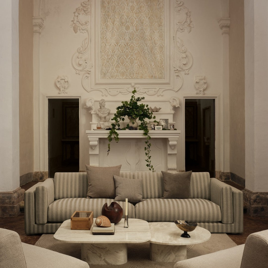 Beige and cream striped sofa with neutral throw pillows in a stylish living room setting. Elegant, modern design.