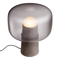 Gray glass table lamp with a smooth sphere shade and a matte concrete base, creating a modern, minimalist aesthetic.
