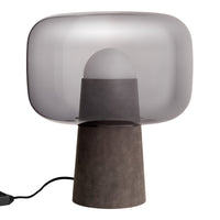 Grey-tinted glass shade lamp with a textured dark base, blending modern elegance with minimalist design.
