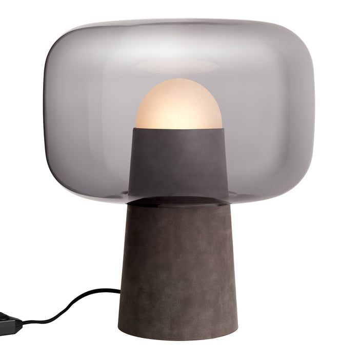 Modern table lamp with a smoky grey shade and a sleek black base. Round white bulb creates a soft, warm glow.