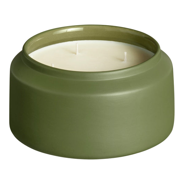 "Green ceramic candle holder with a smooth, matte finish and a white wax interior."