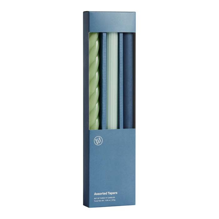Set of four stylish taper candles in teal, light green, navy, and twisted mint patterns, packaged in a sleek blue box.