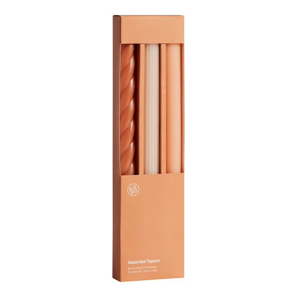 Set of four elegant tapered candles in warm terracotta hues, featuring solid and twisted designs. Perfect for stylish decor.