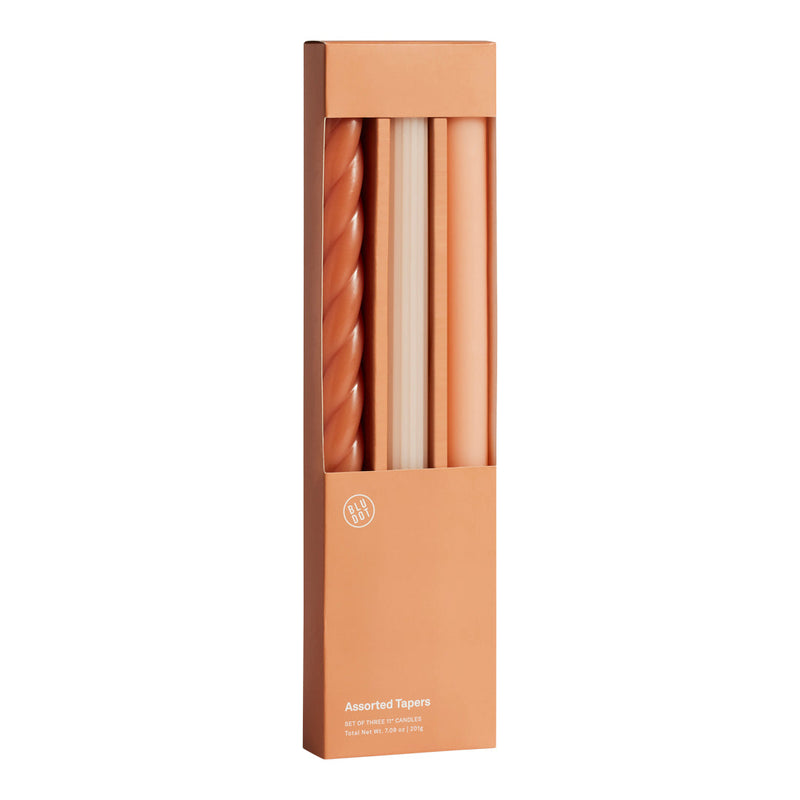 Set of four elegant tapered candles in warm terracotta hues, featuring solid and twisted designs. Perfect for stylish decor.