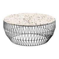Round coffee table with a speckled white and black surface, featuring a geometric metal wire base.