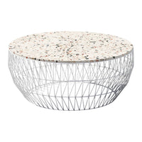 Round coffee table with a speckled white terrazzo top and a geometric silver wire base. Perfect for modern decor.