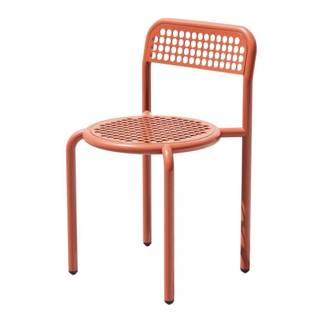 Orange perforated metal chair with a round seat and curved backrest, showcasing contemporary design and vibrant color.
