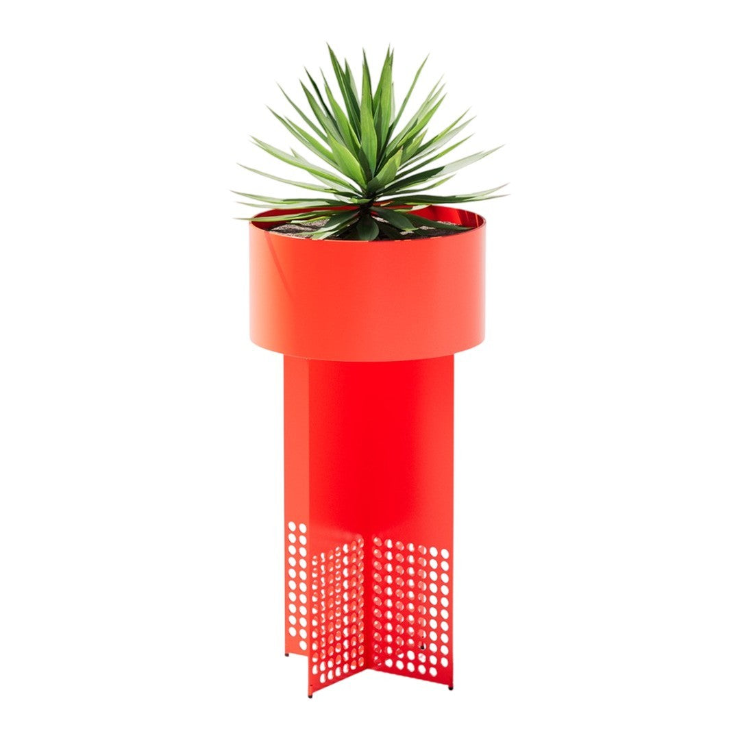 Bright red planter with a perforated design, topped with green foliage for a vibrant, modern look.