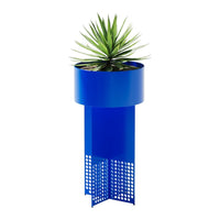 Blue metal planter with geometric perforated design and green plant on top. Modern decor accent for any space.
