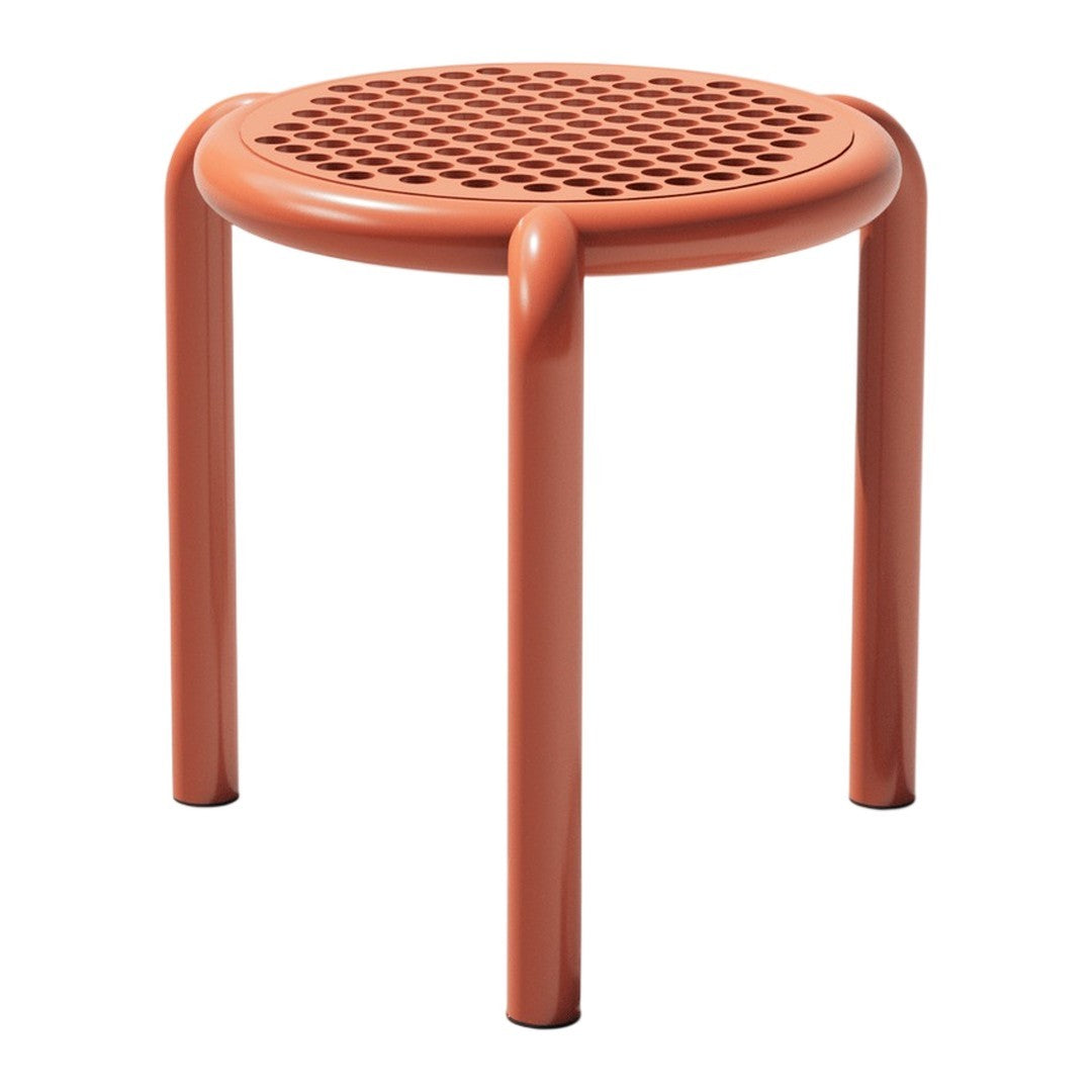 Terracotta round stool with perforated pattern and smooth, rounded legs, perfect for a modern decor.
