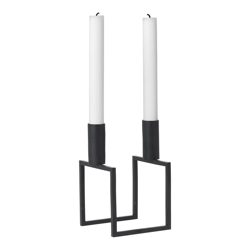 Black metal candle holders with white candles, featuring a modern geometric design.