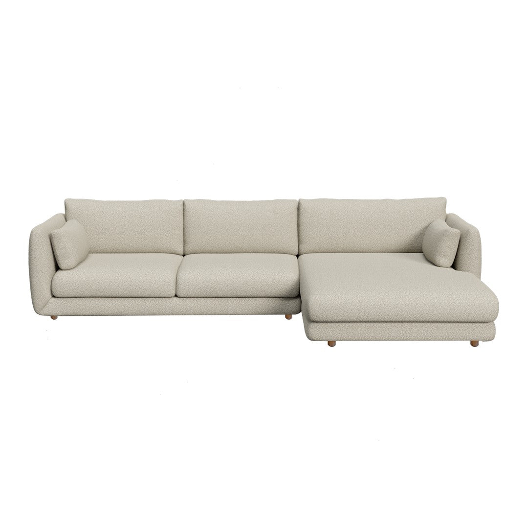 Light beige sectional sofa with smooth fabric and minimalist design, featuring soft cushions and tapered wooden legs.