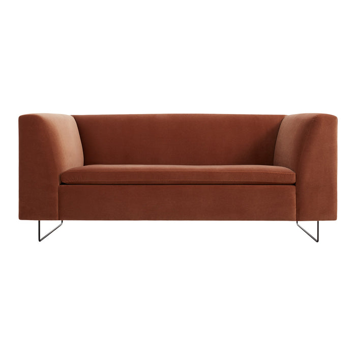 Rust-colored modern sofa with a smooth finish and minimalist metal legs. Ideal for contemporary interiors.