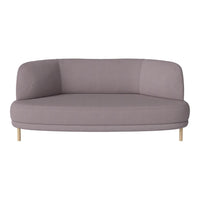 Soft lavender curved sofa with minimalist design and light wooden legs, featuring a smooth, solid fabric texture.