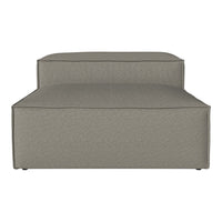 "Neutral gray upholstered accent chair with a simple, textured surface and clean lines."