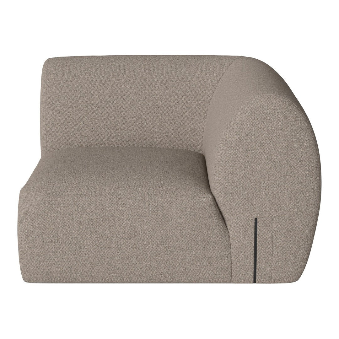 Curved beige sofa with a soft textured fabric, showcasing minimalistic design and modern aesthetic.