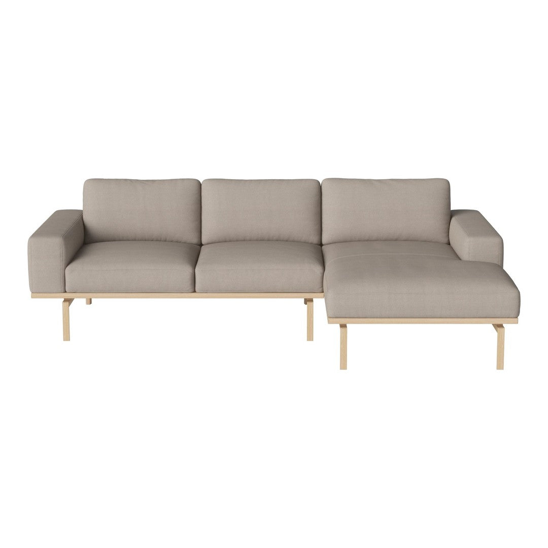Light grey sectional sofa with minimalistic design and natural wood legs, featuring soft, textured upholstery.