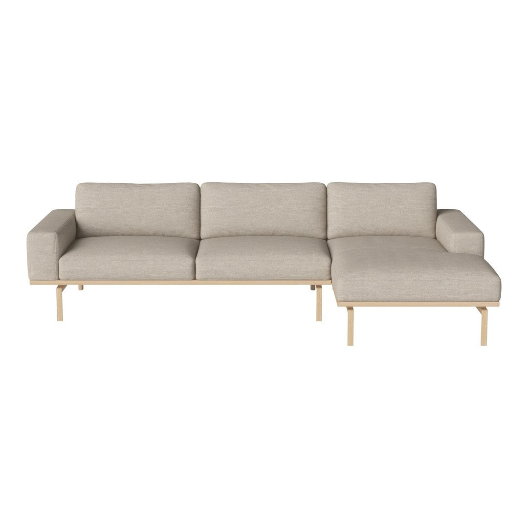 Light beige sectional sofa with smooth fabric and wooden legs, featuring a modern, minimalist design.