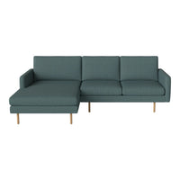 Teal fabric sectional sofa with a sleek design and wooden legs, featuring a minimalistic texture pattern.