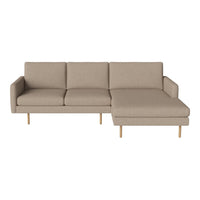 Light beige sectional sofa with a minimalist design and wooden legs, featuring a smooth, solid fabric texture.