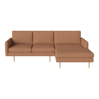 Rust-colored sectional sofa with a minimalist design and textured fabric upholstery, featuring a sleek wood leg finish.