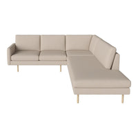 Beige sectional sofa with a minimalist design and smooth fabric texture, complemented by light wooden legs.